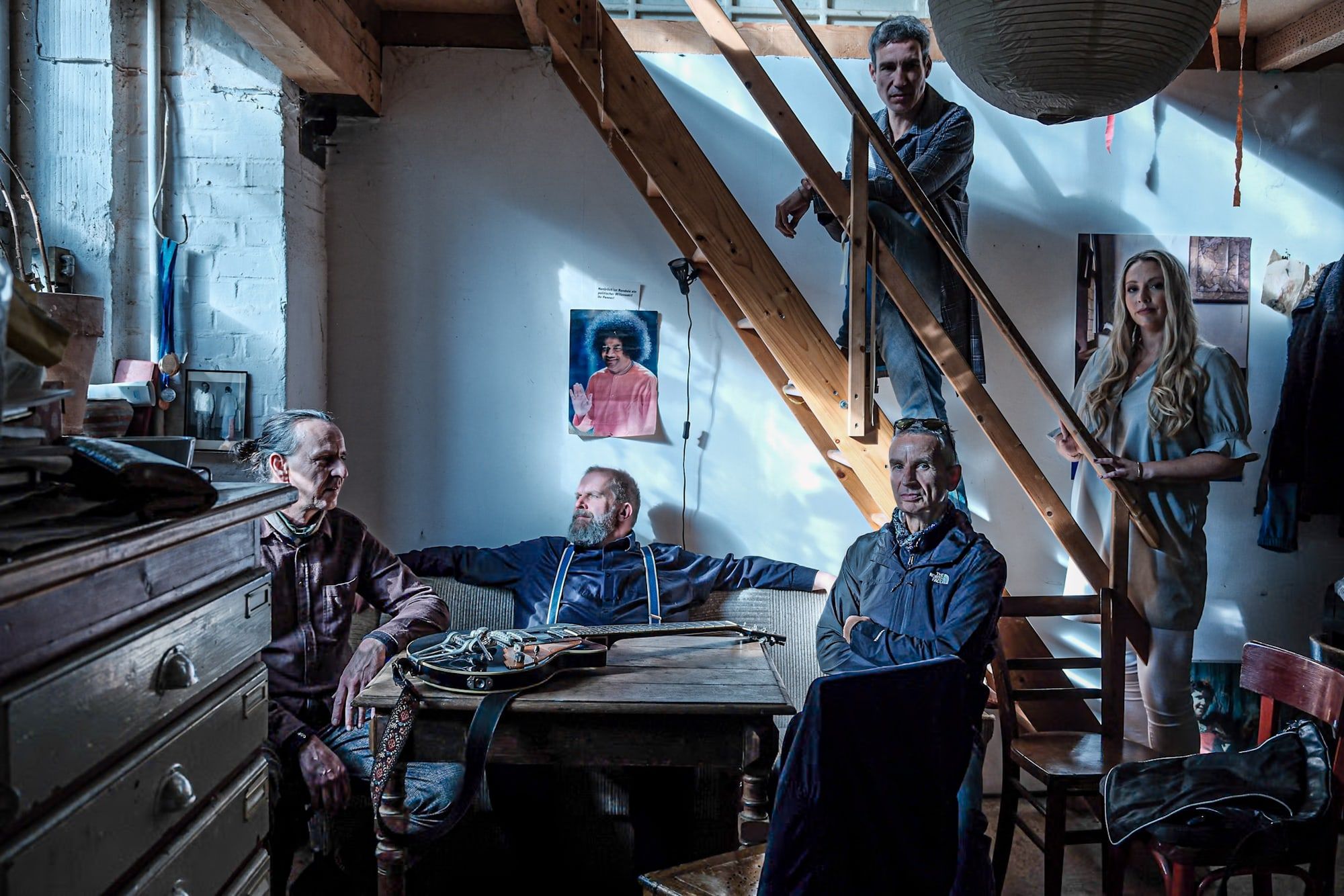 Die Band verteilt auf Sofa und Treppe in einem Atelier