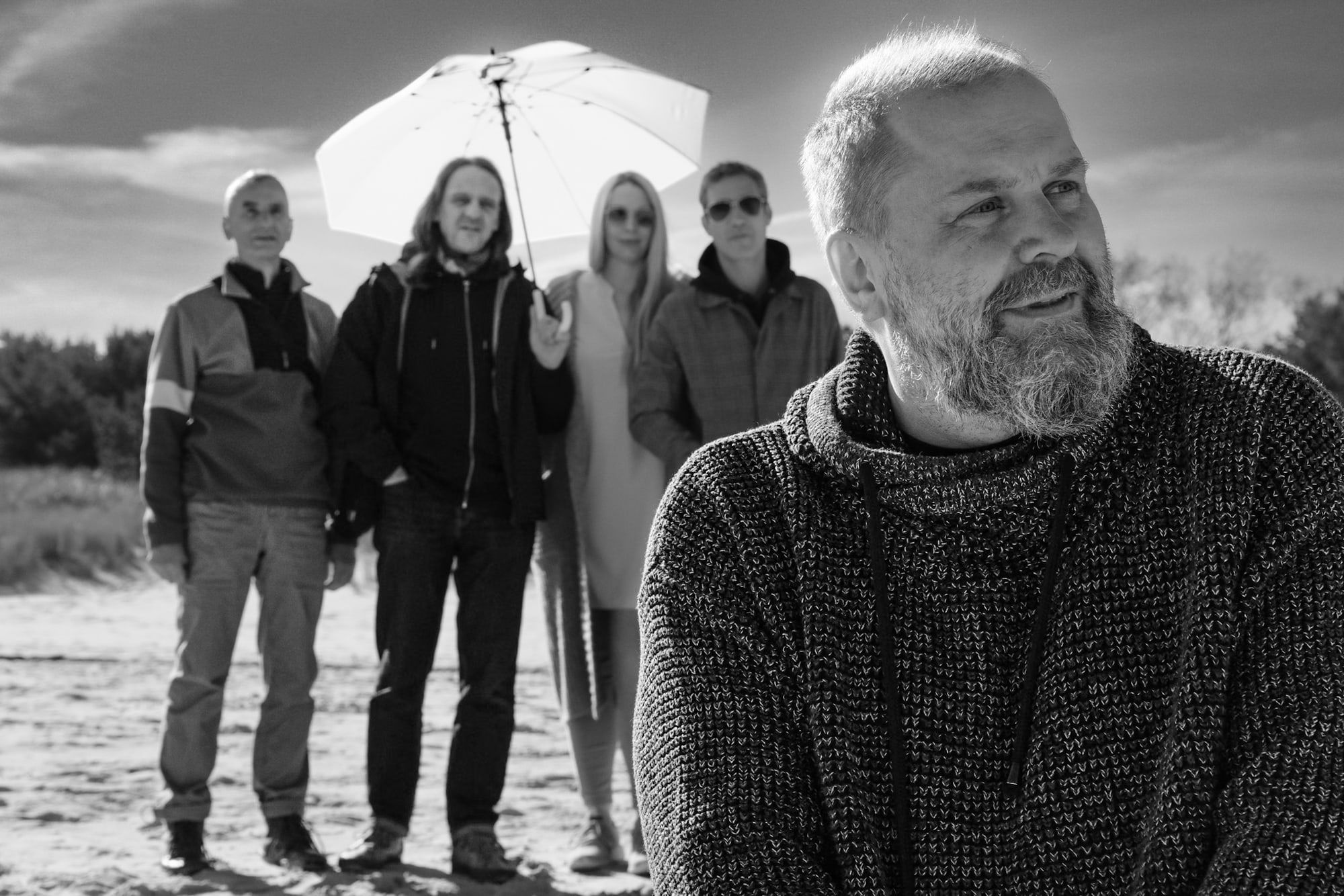 Die Band am Strand mit Sonnenschirm, Gunter Schwarz lächelt vorn ins Bild