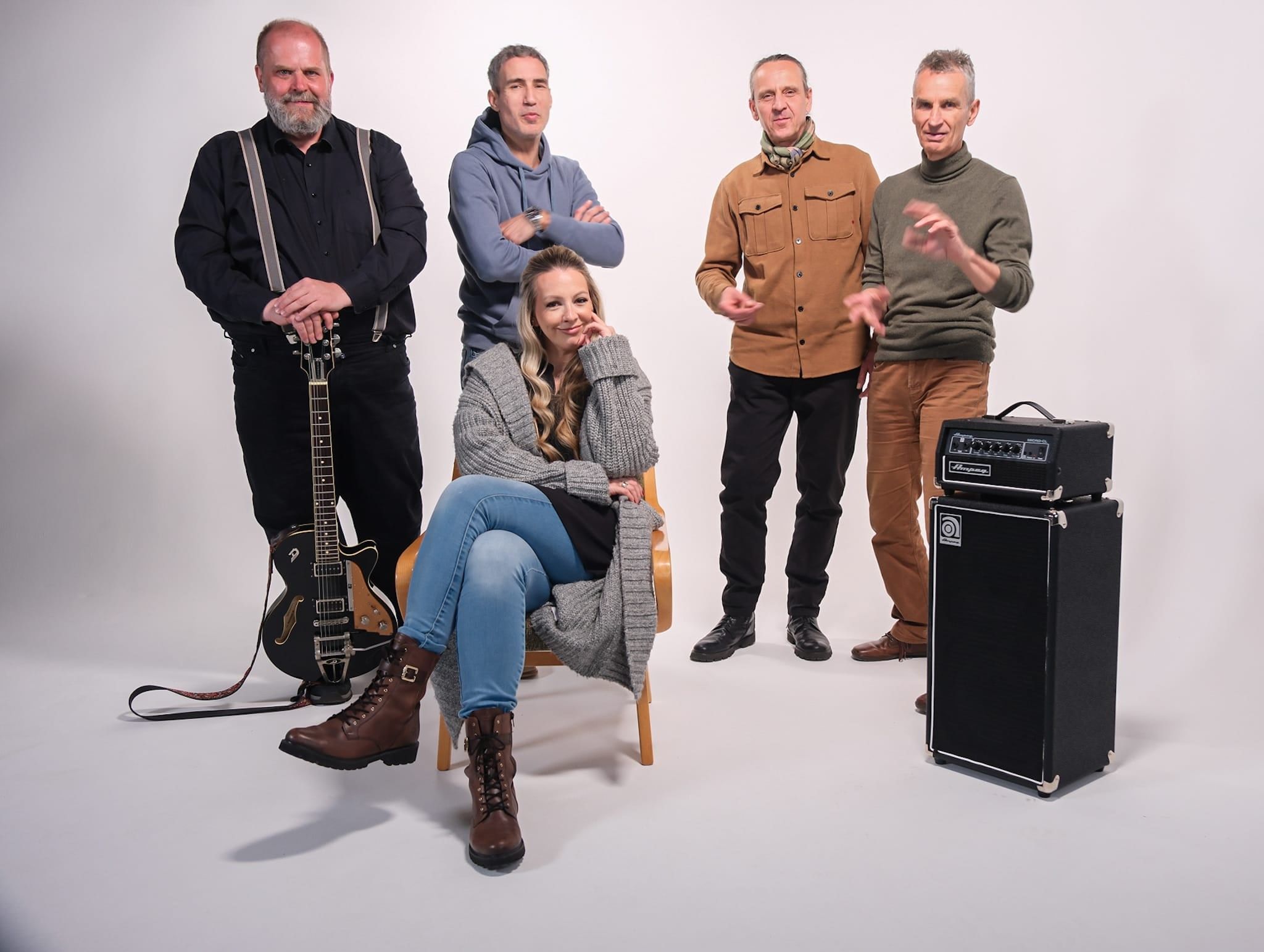 Die Band vor weißem Hintergrund mit Verstärker, Konstanze Gerlach sitzt vorn